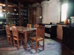 a kitchen with a wooden table with chairs and an oven at Espacio Circular Eco Hostel in San Marcos Sierras +15 photos