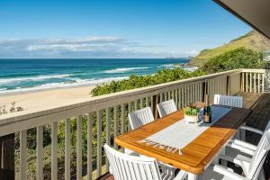a table and chairs on a balcony with the beach at Lawsons at Blueys in Blueys Beach