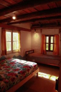 a bedroom with a bed in a room with windows at Espacio Circular Eco Hostel in San Marcos Sierras