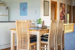 a kitchen with a wooden table and chairs at Lawsons at Blueys in Blueys Beach +13 photos