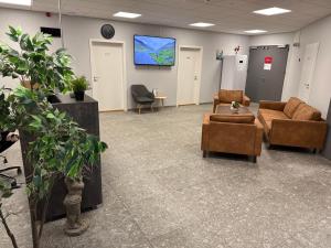 a waiting room with couches and a flat screen tv at Tjarna Hotel in Keflavík