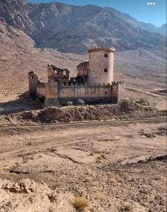 an old building in the middle of the desert at القويرة in El Quweira