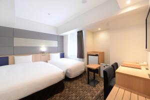 Habitación de hotel con 2 camas y escritorio en Vessel Inn Ueno Iriya Ekimae, en Tokio