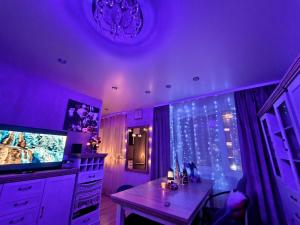 a purple room with a table and a tv at Station and Border Comfort Art and Cats Inn - Комфорт у вокзала и границы Арт и Кот in Narva