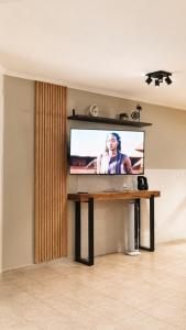 a flat screen tv on a wall in a living room at Caelum House Familiar Con Cochera in Rafaela