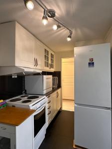 a kitchen with white appliances and a white refrigerator at Apartment in Måløy in Måløy