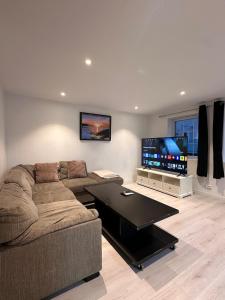 a living room with a couch and a flat screen tv at Apartment in Måløy in Måløy