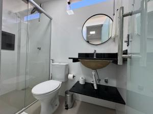 a bathroom with a toilet and a sink and a mirror at M e M Studio novo 107 in Ipatinga
