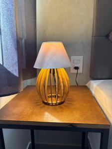 a lamp sitting on top of a table next to a bed at M e M Studio novo 107 in Ipatinga +6 photos