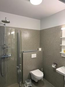 a bathroom with a shower and a toilet and a sink at Tjarna Hotel in Keflavík +13 photos