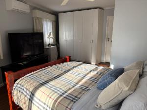 a bedroom with a bed and a flat screen tv at Guest ensuite room with private entrance in Melbourne