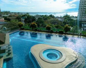 a large swimming pool with a view of a city at STAYLUXIA - MANILABAYVIEW - Luxury and Superior Suites with, Balcony -except Studios- Pool, Netflix & Gym- Housekeeping Available - in Manila