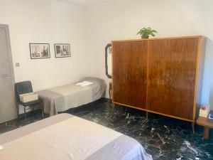 a room with two beds and a wooden cabinet at CASA di Pi in Bologna