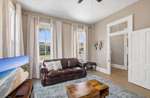 a living room with a leather couch and a tv at Sand and Sea Manor in Galveston