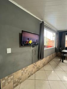a room with a flat screen tv on a wall at 10 - Casa completa com piscina, Wi-Fi e Garagem in São Leopoldo