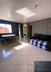 a living room with a bed and a table at 10 - Casa completa com piscina, Wi-Fi e Garagem in São Leopoldo