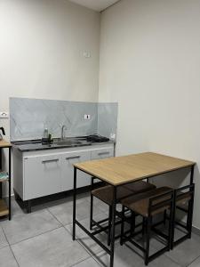 a kitchen with a wooden table and a sink at Estadia Perfeita com AC, Apto a minutos do Aeroporto Gru in Guarulhos
