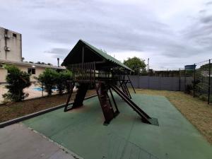 a playground with a slide on a green floor at Apartamento com sacada, estacionamento e piscina in São Leopoldo