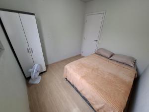 a small bedroom with a bed and two closets at Apartamento com sacada, estacionamento e piscina in São Leopoldo
