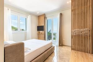 a bedroom with a bed and a large window at New Dhermi Icon 2 - Parking in Dhërmi