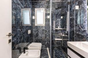 a black tiled bathroom with a toilet and a sink at New Dhermi Icon 2 - Parking in Dhërmi