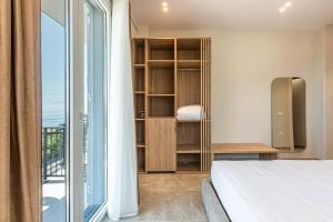 a bedroom with a bed and a large window at New Dhermi Icon 2 - Parking in Dhërmi