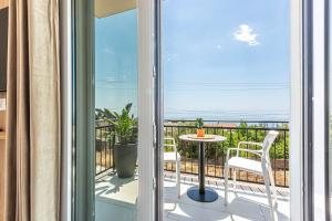 a balcony with a table and chairs and a view of the ocean at New Dhermi Icon 2 - Parking in Dhërmi +4 photos