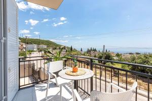 a patio with a table and chairs on a balcony at New Dhermi Icon 2 - Parking in Dhërmi