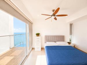 a bedroom with a blue bed and a balcony at Resort Playa Azul Departamentos Frente al Mar in Tonsupa +81 photos