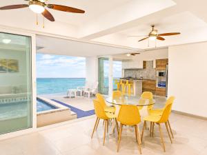 a dining room with a table and chairs and the ocean at Resort Playa Azul Departamentos Frente al Mar in Tonsupa