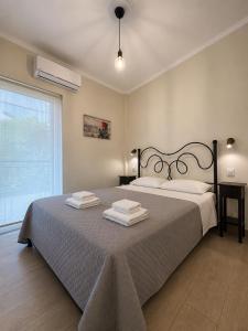 a bedroom with a large bed with towels on it at Angelland Luxury Suites in Nafpaktos