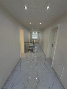an empty room with a white marble floor and a staircase at Luksuzna kuća sa bazenom in Modriča