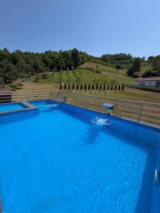 a large pool of blue water in a field at Luksuzna kuća sa bazenom in Modriča