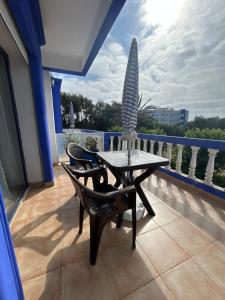 a patio with a table and chairs on a balcony at Chez Bouchra Suite familiale in Pont Blondin
