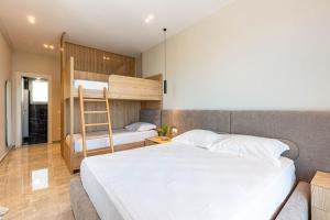 a bedroom with a bed and a ladder and a bunk bed at New Dhermi Icon 3 - Parking in Dhërmi +3 photos