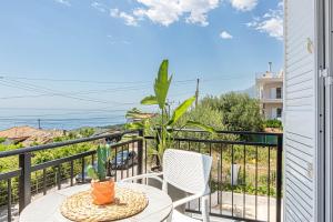 a patio with a table and chairs on a balcony at New Dhermi Icon 3 - Parking in Dhërmi