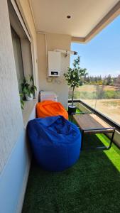 a balcony with a blue bean bag chair and a table at Cozy Urban Nest in La Marsa