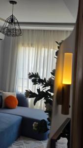 a living room with a blue couch in front of a window at Cozy Urban Nest in La Marsa