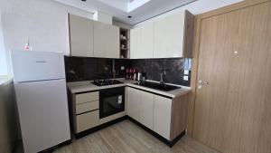 a kitchen with a white refrigerator and a sink at Cozy Urban Nest in La Marsa
