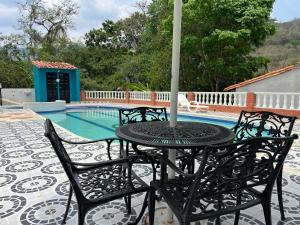 a table and chairs with an umbrella next to a pool at Hotel para descanso con piscina in San Gil