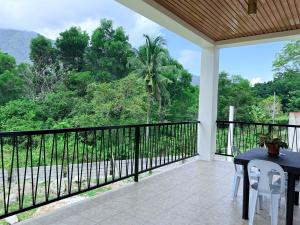 a balcony with a table and chairs and a view at Central 1 Suites in Mambajao