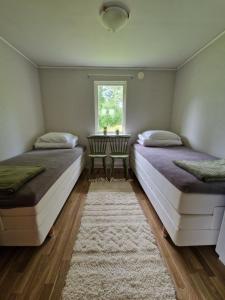 two beds in a room with a window at Havsnära stuga in Varberg