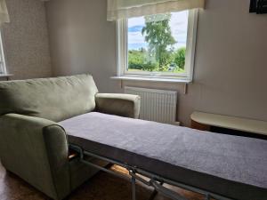 a hospital bed in a room with a window at Havsnära stuga in Varberg +7 photos