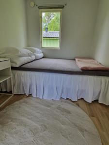 a bed sitting in a room with a window at Havsnära stuga in Varberg