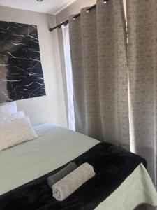 a bed with a towel laying on it next to a window at The Gardens view lodge in Bushbuckridge