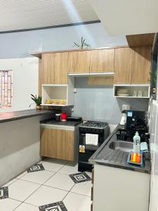 a kitchen with a sink and a stove top oven at M&A Hospedagem in Cruzeiro do Sul