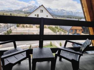 a table and chairs on a balcony with a view of mountains at Durmitor sky in Žabljak