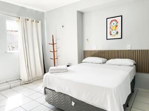 a bedroom with a large bed with white sheets at Hotel Oiticica in Fortaleza