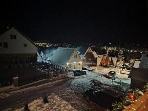 a house with snow on the ground at night at Durmitor sky in Žabljak