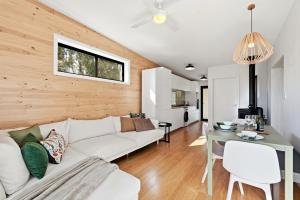 a living room with a white couch and a table at Hudsons Hideaway - Cosy Eco Cabin, Rainforest Walks in Dorrigo